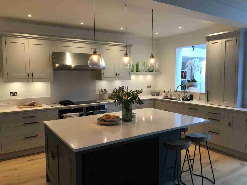 Kitchen island with bar stools and pendant lights photographed during a July 2021 project update
