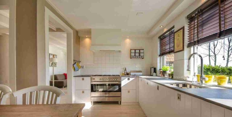 Freshly painted open-plan kitchen diner with range cooker and garden window