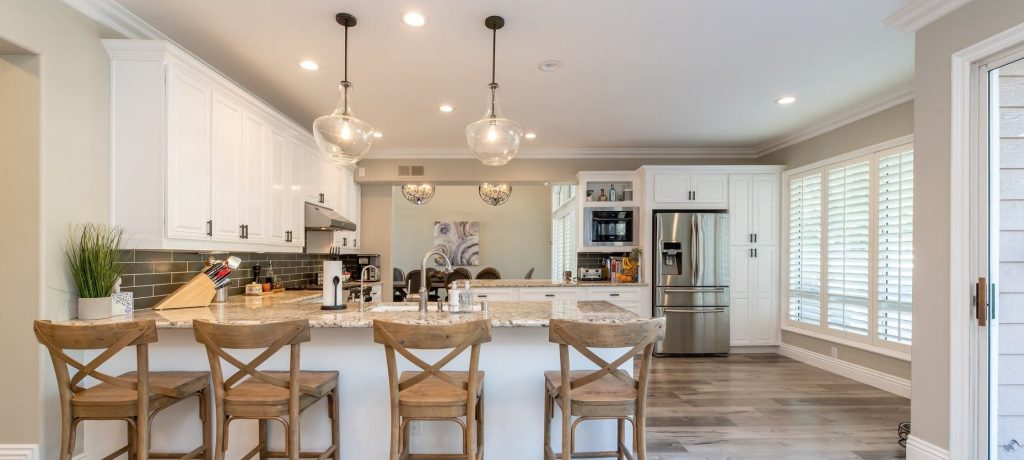 White kitchen with island and bar stools decorated by painters and decorators in Fulham
