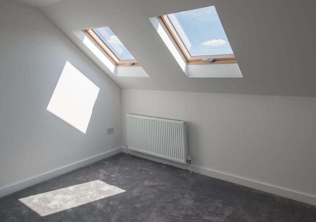 Finished loft conversion room in Fulham with skylights and dark flooring