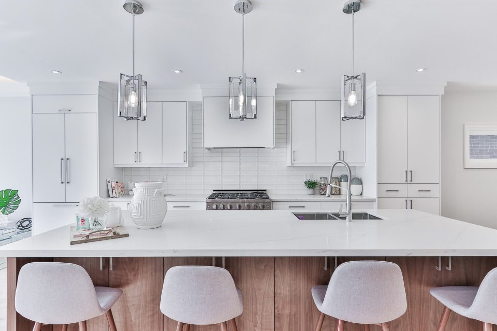 Shaker style white kitchen with pendant lighting and panelled wall fitted in Fulham