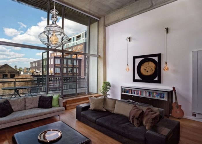 Open-plan living room with Crittall style glazing and oak flooring maintained by London decorators