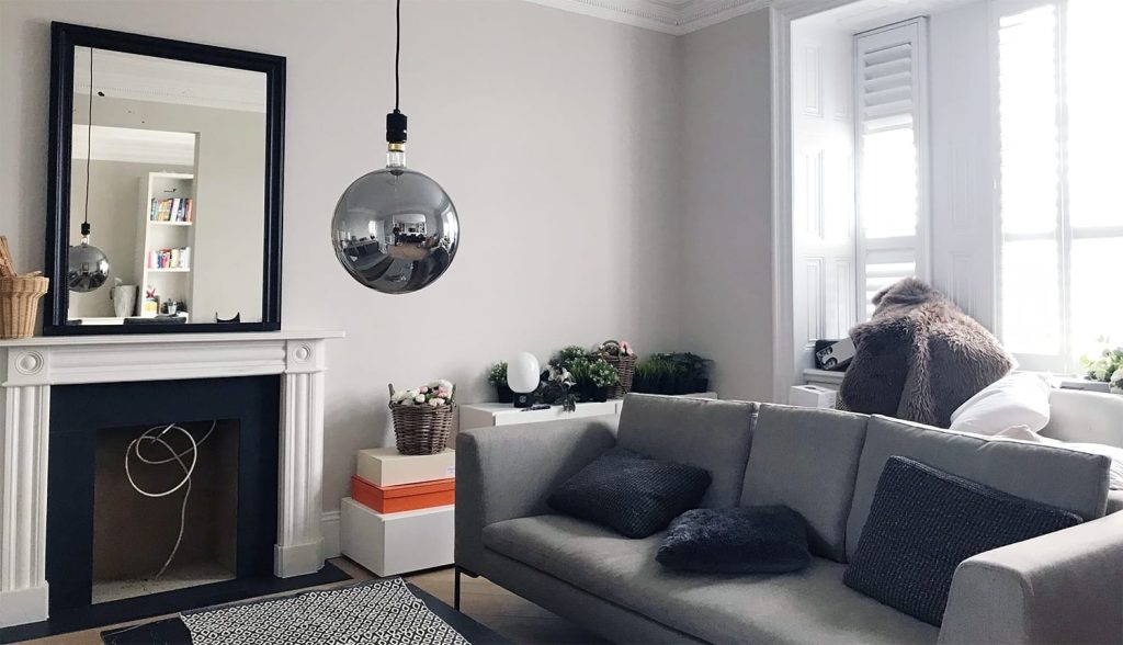 Living room with grey sofa and period fireplace repainted by painters and decorators in Fulham