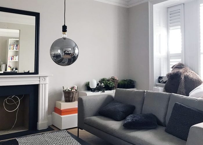 Grey sofa and painted period fireplace in a London living room finished by local decorators